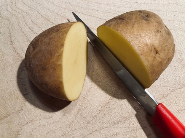 Halbiere die Kartoffeln mit dem Messer. Lass dir dabei eventuell helfen.